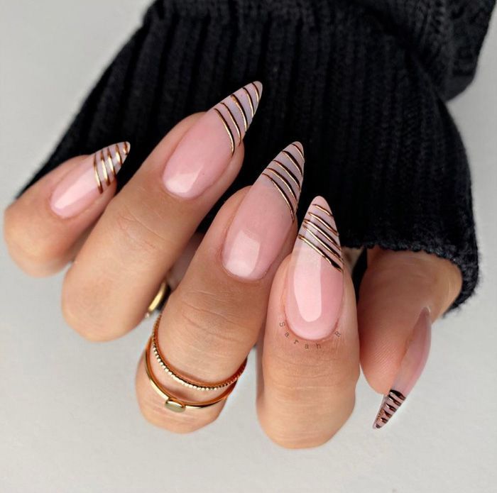 Elegant Stiletto Nails with Chic Metallic Gold Stripes on Soft Nude Base