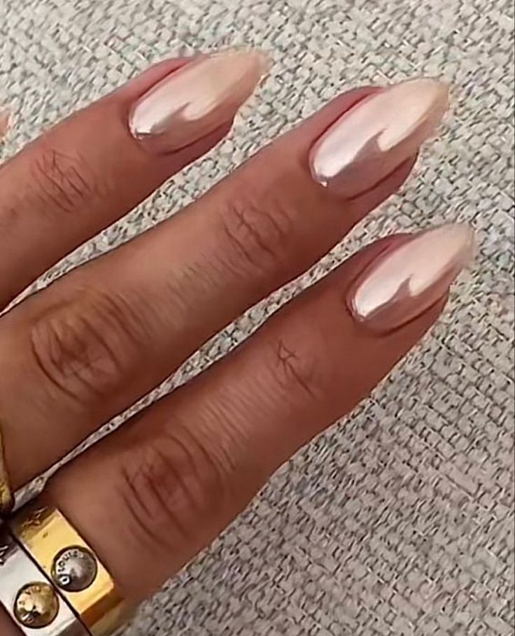 Chic Ombre Almond-Shaped Nails in Soft Pink and Nude with Glossy Finish and Metal Accents.