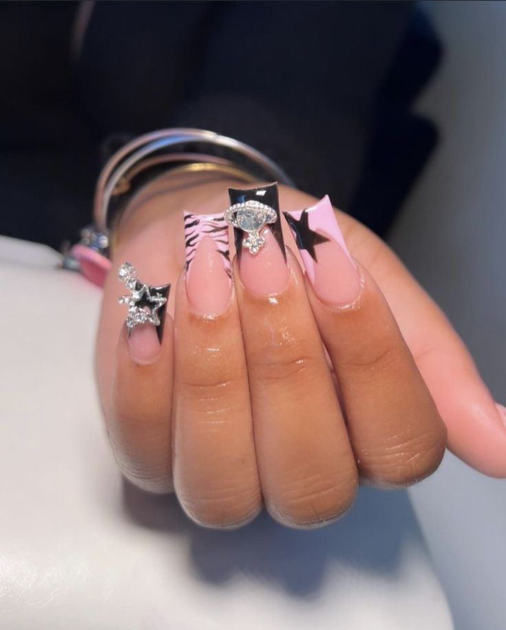 Striking Pink and Black Nail Design with Bold Stars, Playful Animal Print, and Glamorous Sparkles.