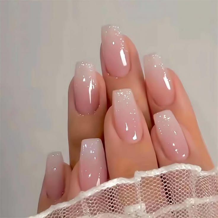 Elegant Ombre Nail Design with Pink Gradient and Subtle Glitter Accents in a Modern Squared Shape.