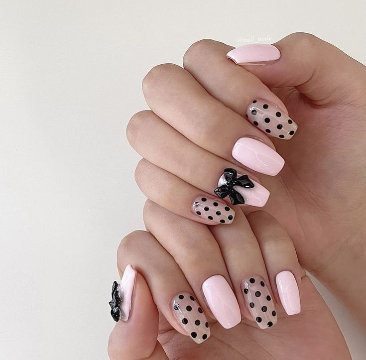 Modern Feminine Nail Design: Soft Pink with Playful Black Polka Dots and Whimsical Bows