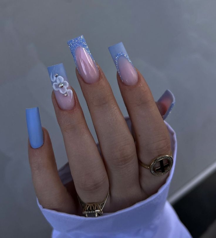 Elegant Nail Art Design: Soft Blues, Nude Tones, and Floral Embellishments.