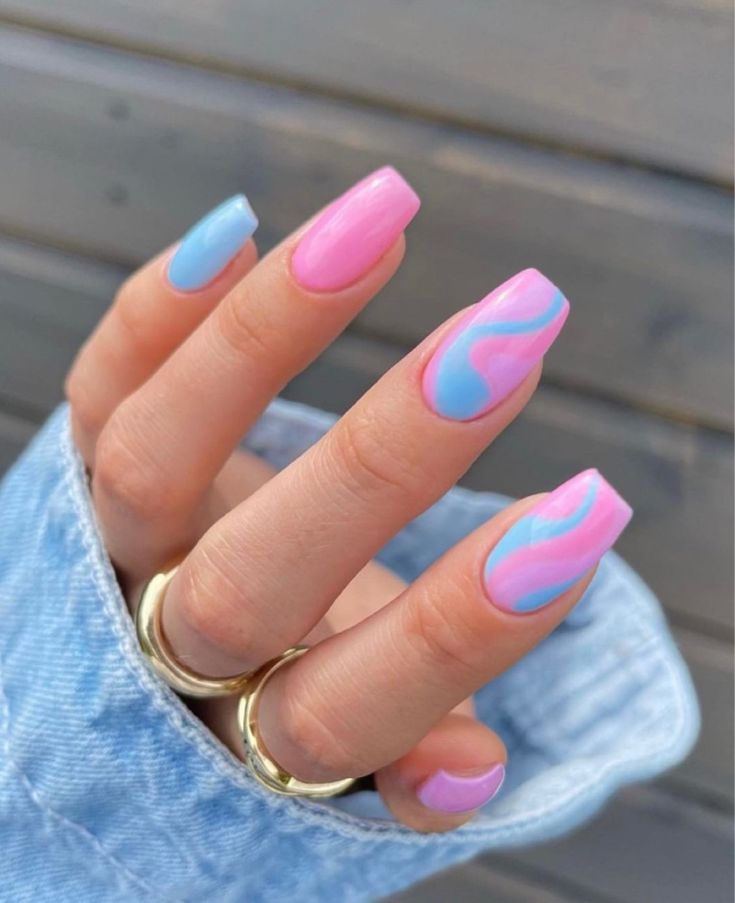 Playful Wave Pattern Nail Design in Soft Pink and Pastel Blue for a Trendy Statement Look.