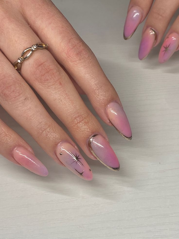 Elegant Ombre Nail Design with Pink Gradient and Starburst Accents for Modern Almond Tips.