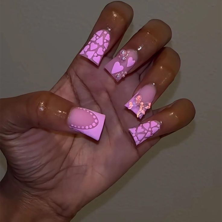 Vibrant Pink Nail Design with Whimsical Patterns and Decorative Elements.