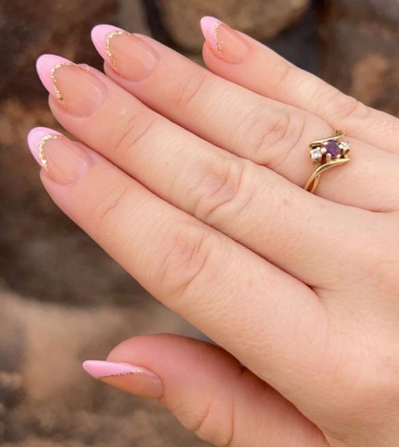 Sophisticated Soft Pink Nail Design with Gold Accents and Elegant Ring.