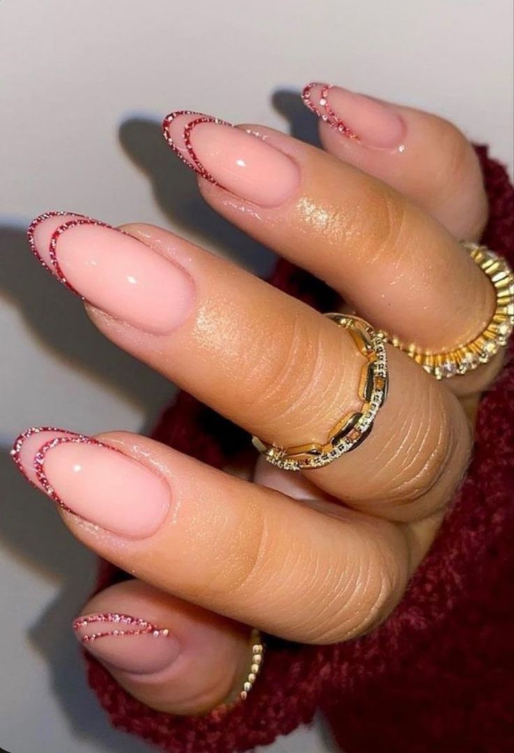 Chic Sophistication: Soft Pink Nails with Glittery Red Tips and Stylish Rings