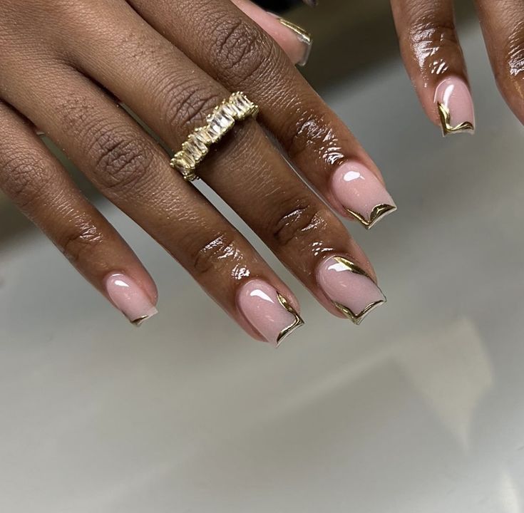 Sophisticated Elegant Nude Nails with Chic Gold Tips and Delicate Ring Accent.