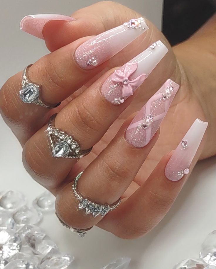 Chic Romantic Manicure: Long Pink and White Nails with Glitter, Bow, and Rhinestones.