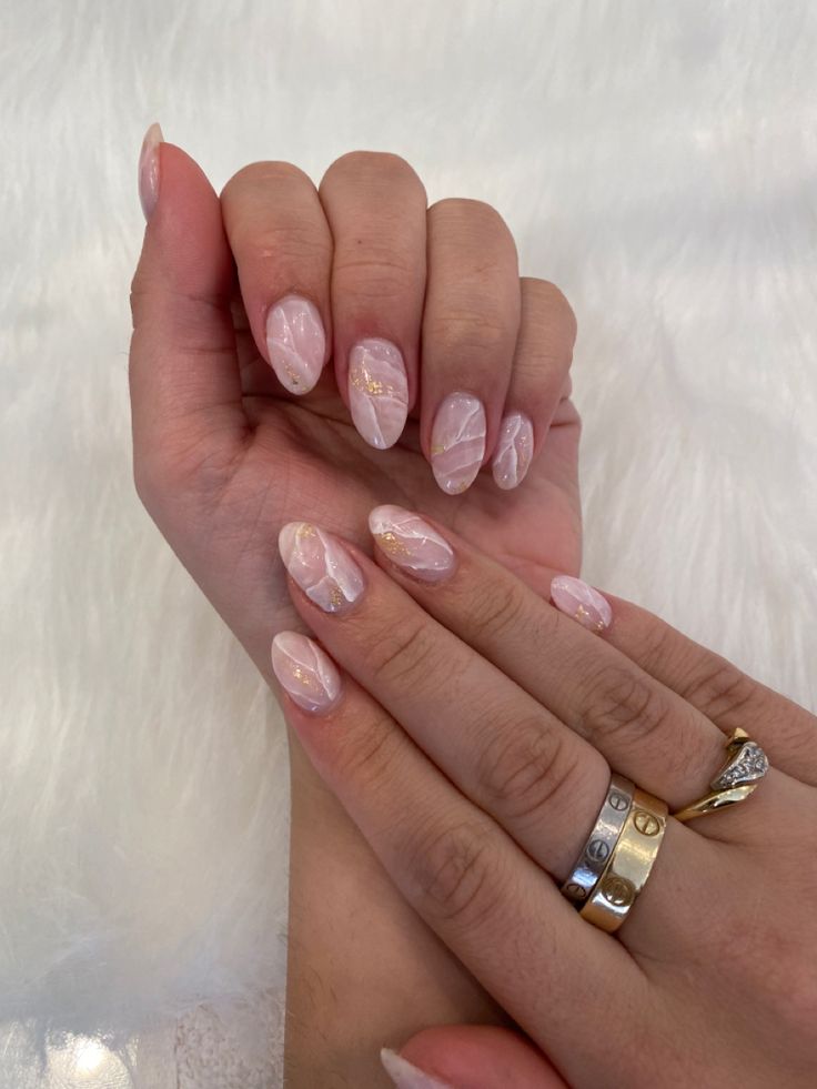 Sophisticated Soft Pink Marble Nail Design with Glamorous Gold Accents