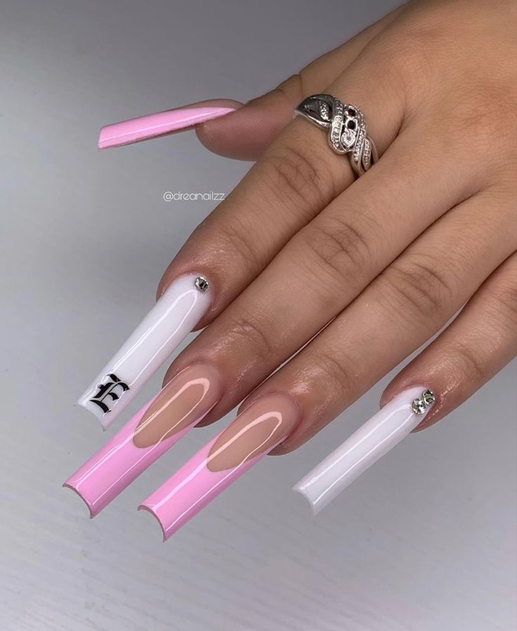 Chic Pink and White Long Nails with Artistic Negative Space and Elegant Gem Accents.