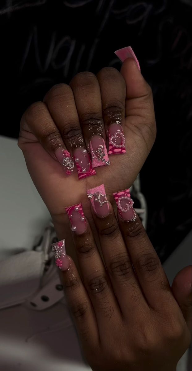 Playful Pink and Transparent Acrylic Nail Design with Glamorous Patterns and Embellishments.