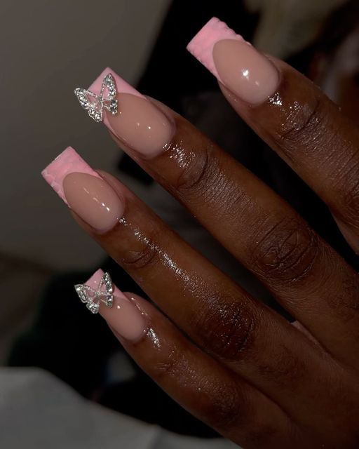 Sophisticated Glossy Nude and Pink Tip Nails Adorned with Rhinestone Butterflies.