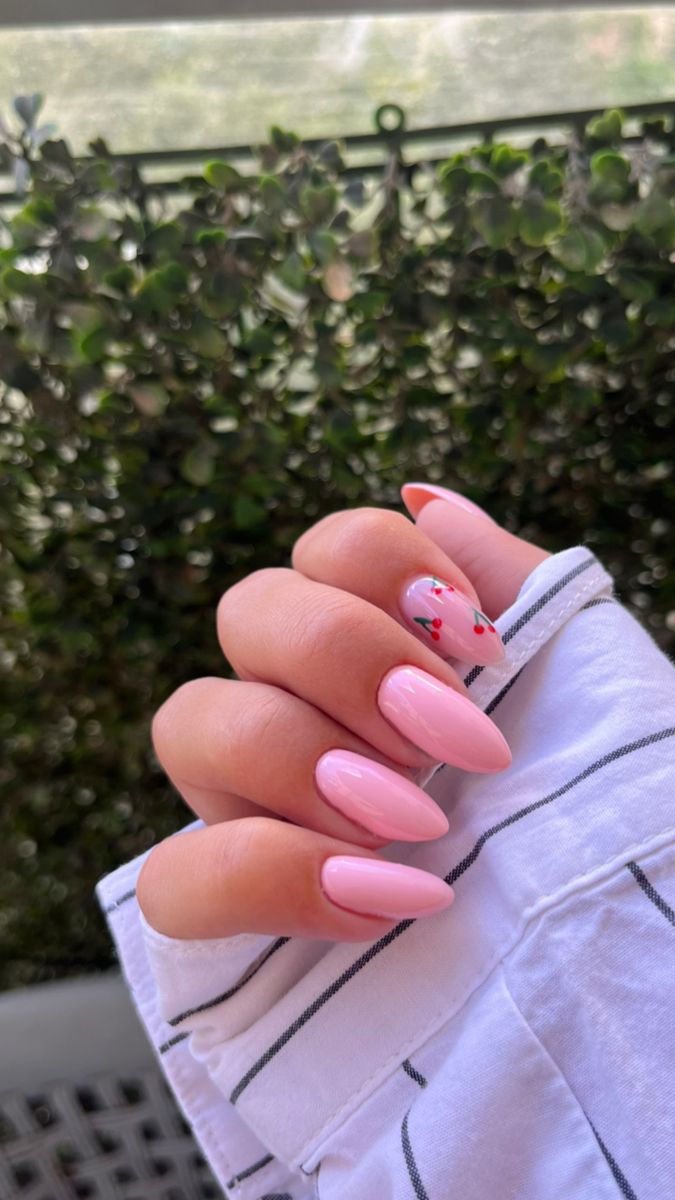 Chic and Playful Soft Pink Almond Nail Design with Floral Accent.