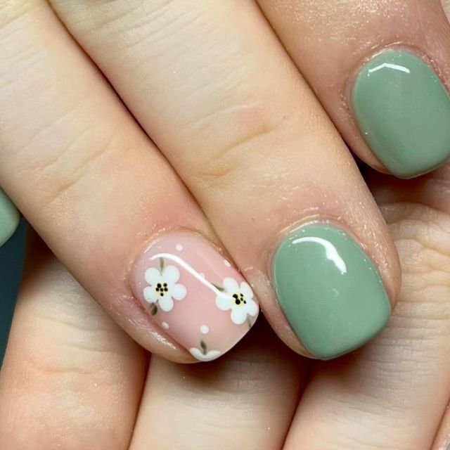 Whimsical Pastel Nail Art: Soft Pink Floral Accent with Soothing Green Base.