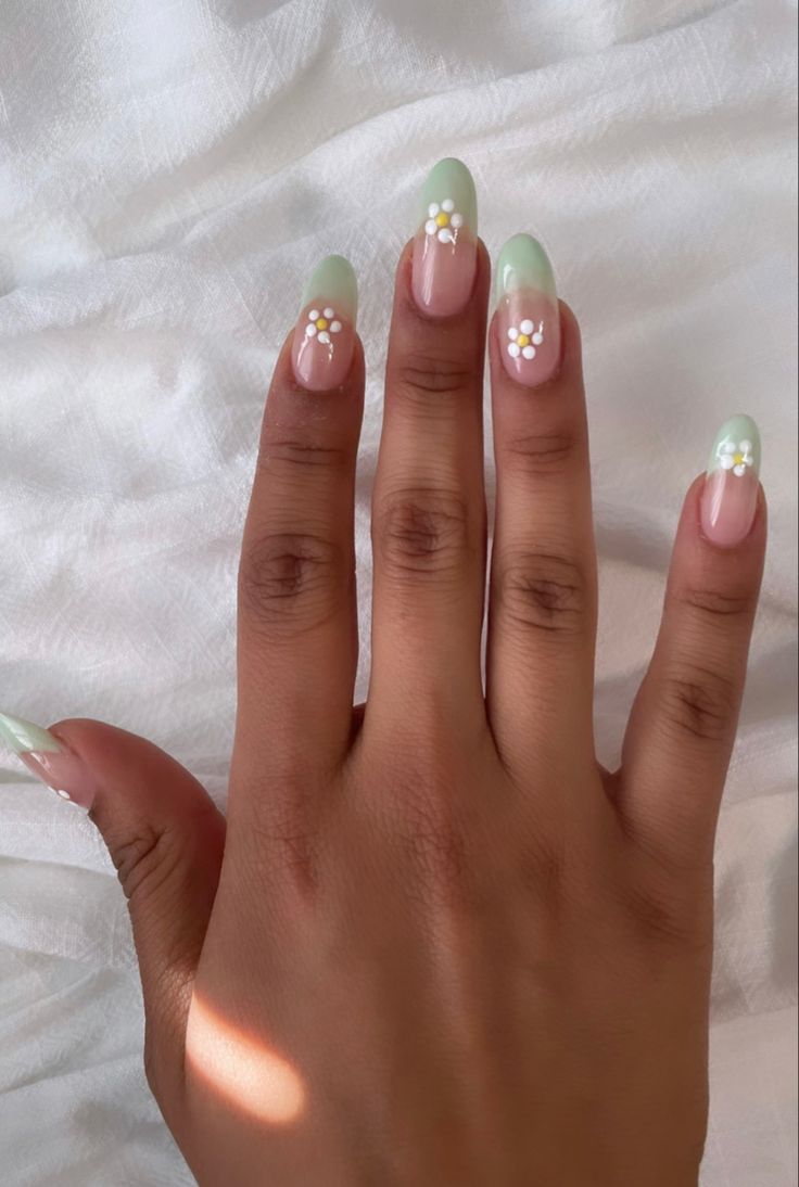 Elegant Green Gradient Nail Design with Floral Accents for a Fresh Spring Look.