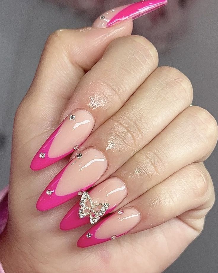 Chic Stiletto Nails: Elegant Nude and Bold Pink Design with Rhinestones and Butterfly Charm.