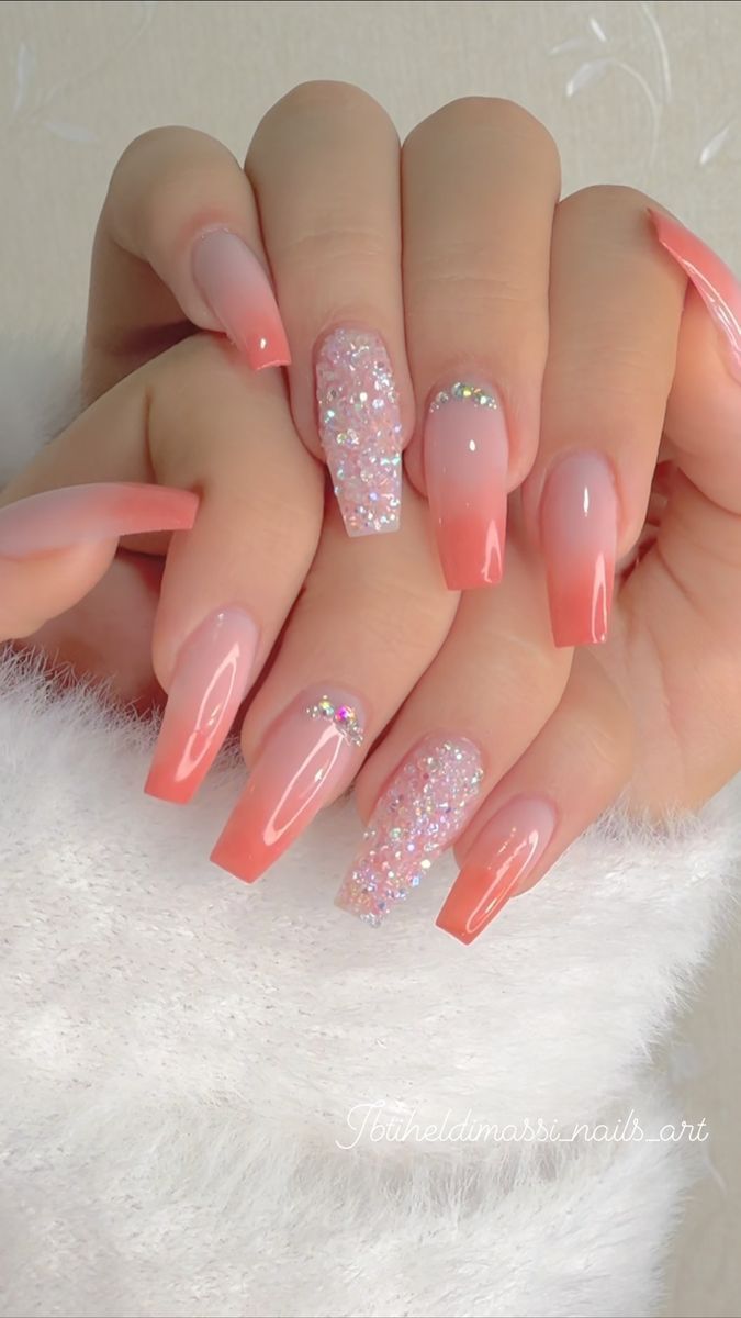 Elegant Ombre Nail Design with Soft Pink and Coral Hues and Glitter Accents on Long Coffin-Shaped Nails.