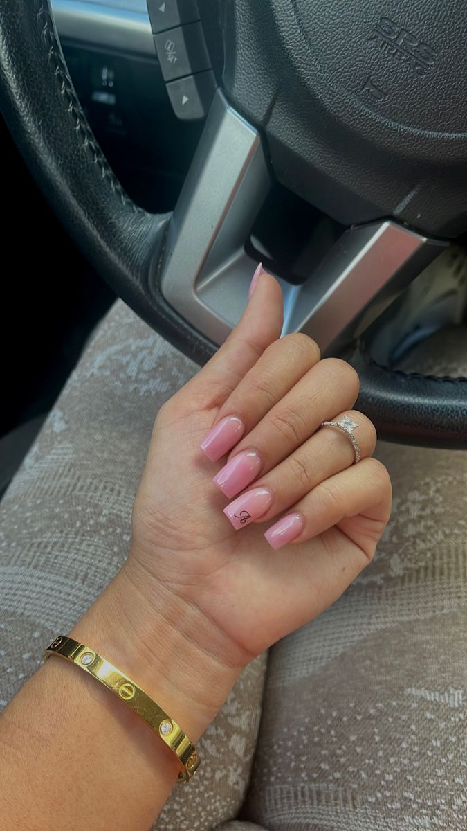 Chic Soft Pink Nail Design with Unique Embellishments and Elegant Jewelry