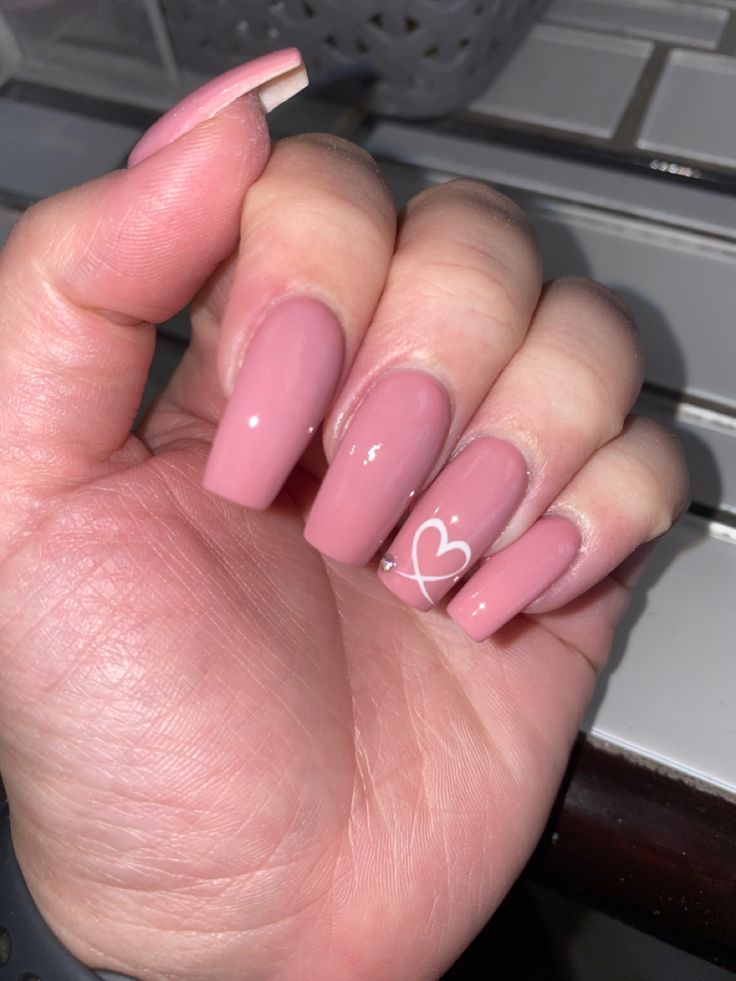 Chic Nude Pink Nails with Glossy Finish and Whimsical Heart Design.