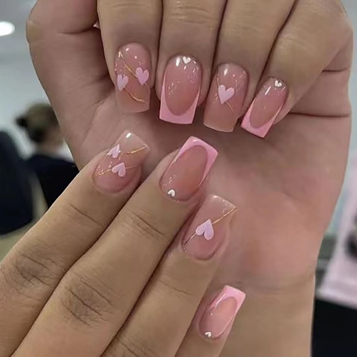 Charming Soft Pink Nail Design with Glossy Finishes, Heart Motifs, and Elegant Gradient Tips.