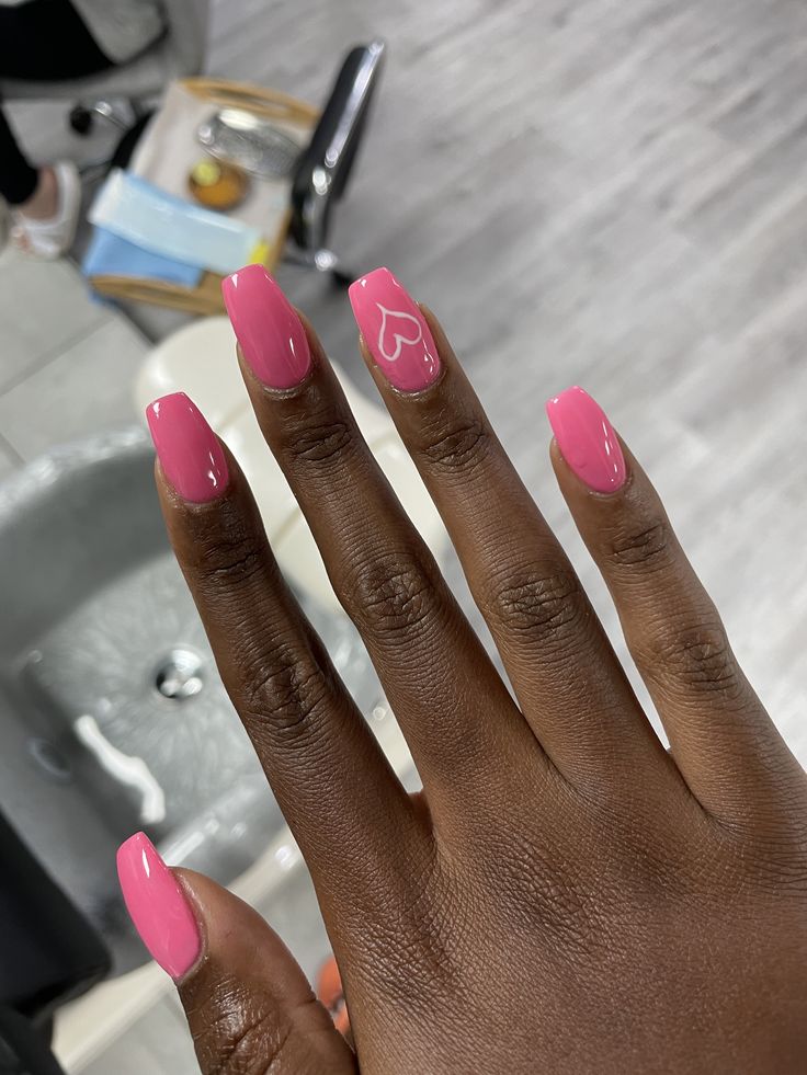 Chic Pink Nails with Glossy Finish and Playful Heart Design for Any Occasion.