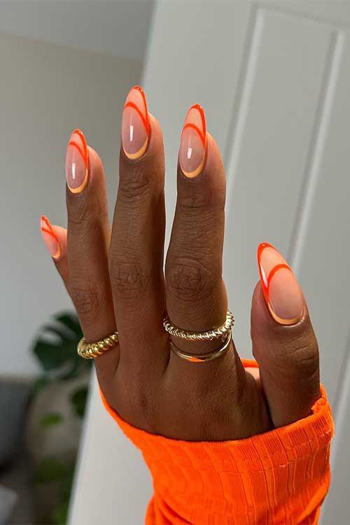 Vibrant Orange and Nude Nail Design: A Stylish Statement with Bold Lines and Elongated Elegance.