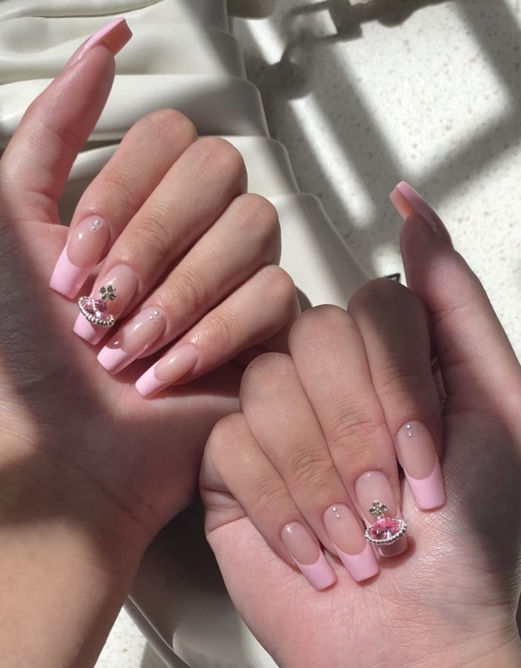 Sophisticated Soft Pink French Tip Nails with Floral Rhinestone Accents.