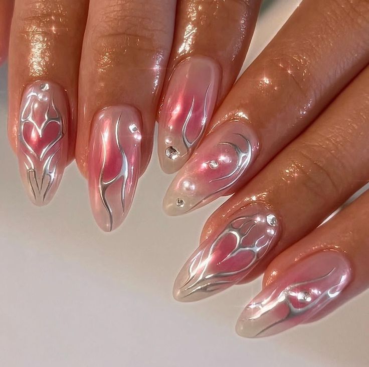 Elegant Floral Nail Design: Soft Pink Hues with Silver Accents and Glamorous Finishes.