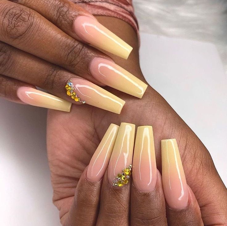 Elegant Ombre Nail Design: Soft Yellow and Nude Shades with Sparkling Gems.