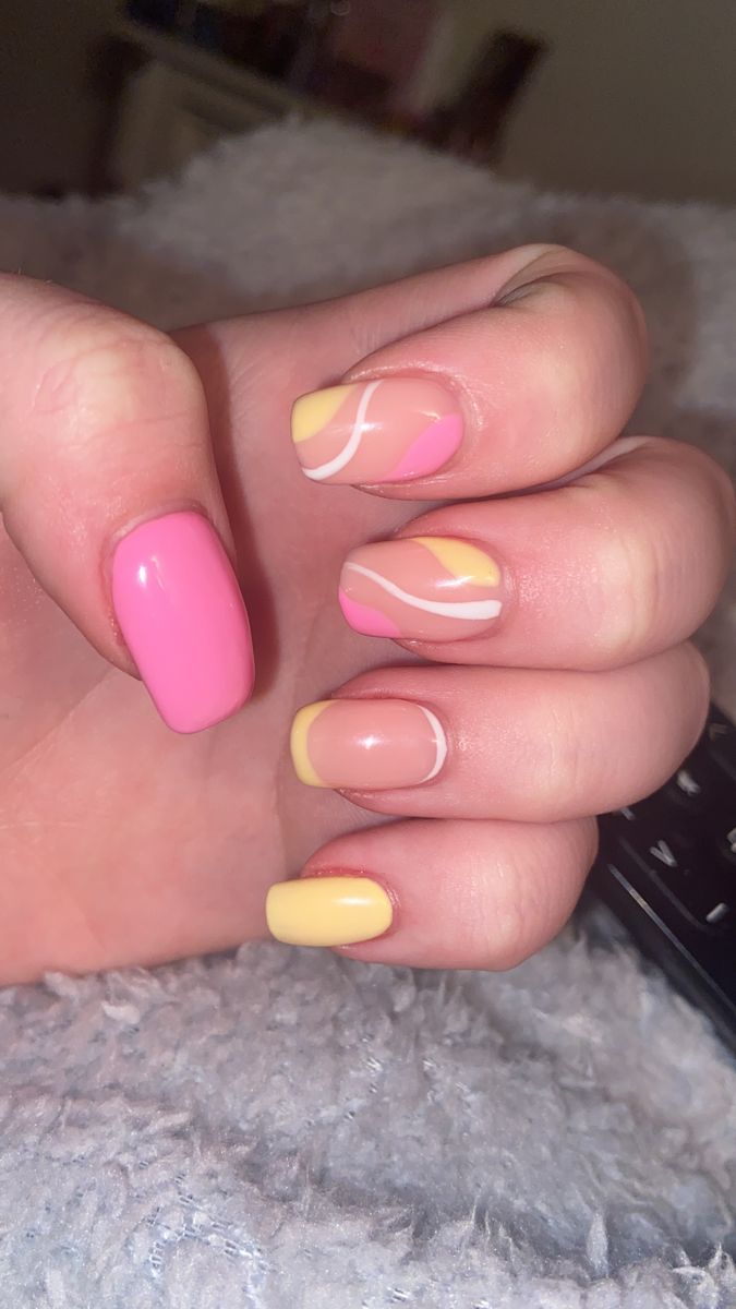 Playful Pastel Nail Design with Swirling Patterns in Pink, Yellow, and Soft Orange.