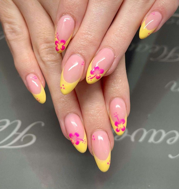 Playful and Elegant Soft Pink Nail Design with Vibrant Yellow Tips and Floral Accents