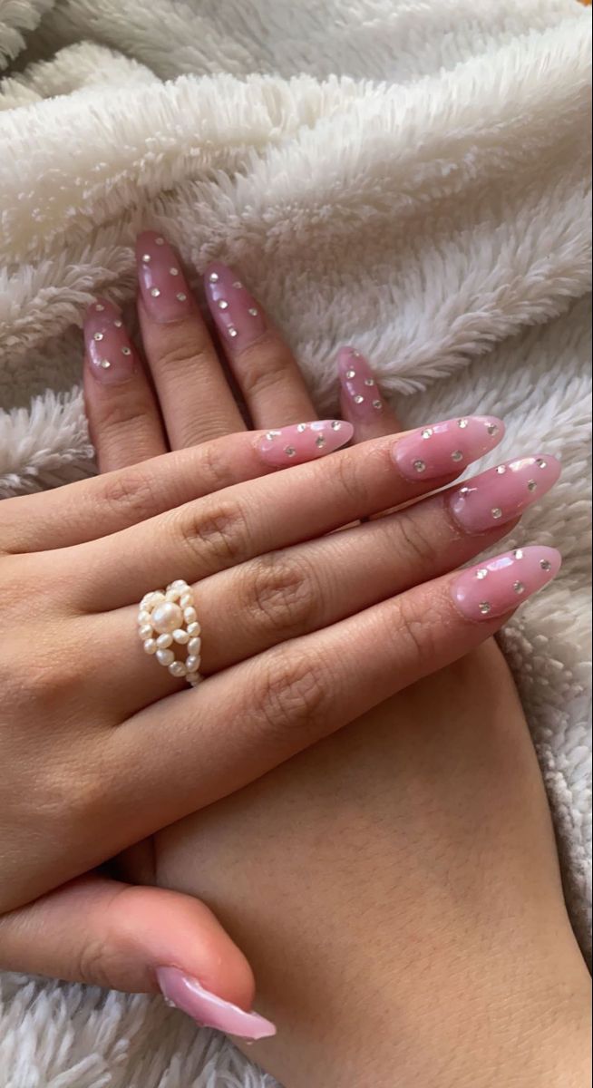 Chic Almond-Shaped Nails: Soft Pink Base with Delicate White Dots and Pearl Ring.