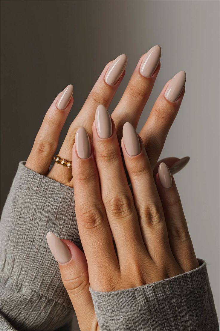 Chic Almond-Shaped Nude Nails: A Versatile Elegance with Delicate Gold Accents.