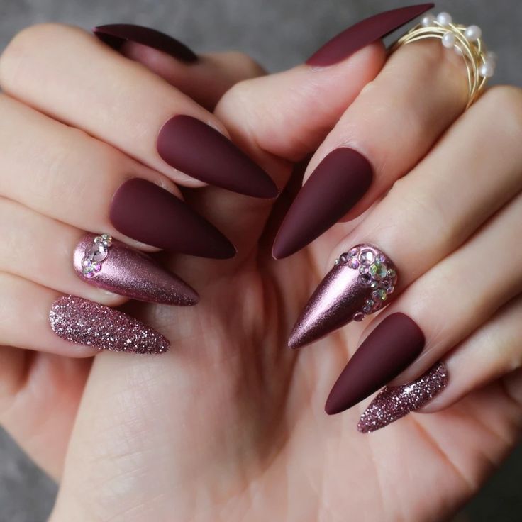 Sophisticated Almond-Shaped Nail Design with Deep Burgundy Matte, Rose Gold Accents, and Rhinestone Glamour.