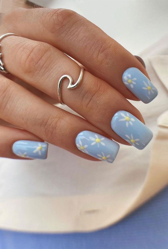 Charming Blue Nail Design with Hand-Painted Daisies for Effortless Spring Elegance.