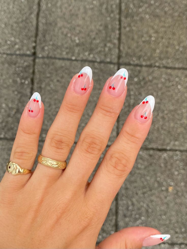 Chic Contemporary French Tip Nail Design with Soft Nude Base, Blue Tips, and Playful Red Dots.