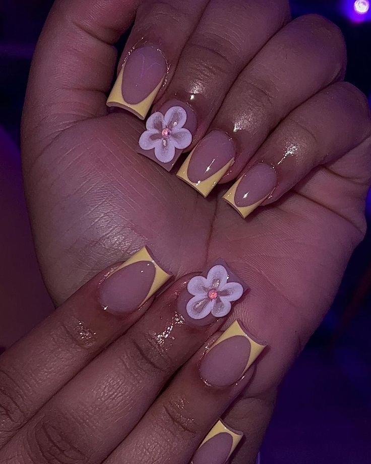 Chic Floral Nail Design with Soft Nude Base and Vibrant Yellow Tips.