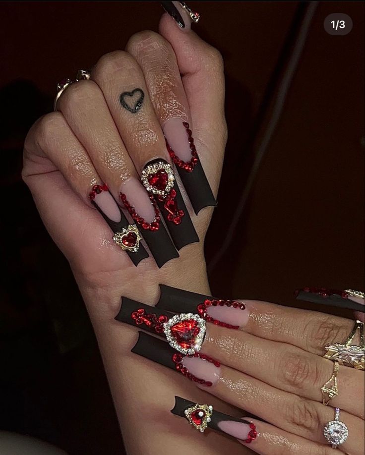 Glamorous Matte Black Stiletto Nails with Romantic Gemstone Heart Designs.