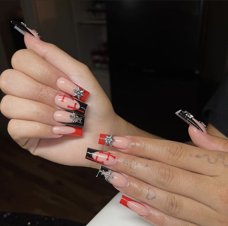 Chic Nail Design with Black, Red, and Nude Tones Enhanced by Metallic Accents and Star Motifs.