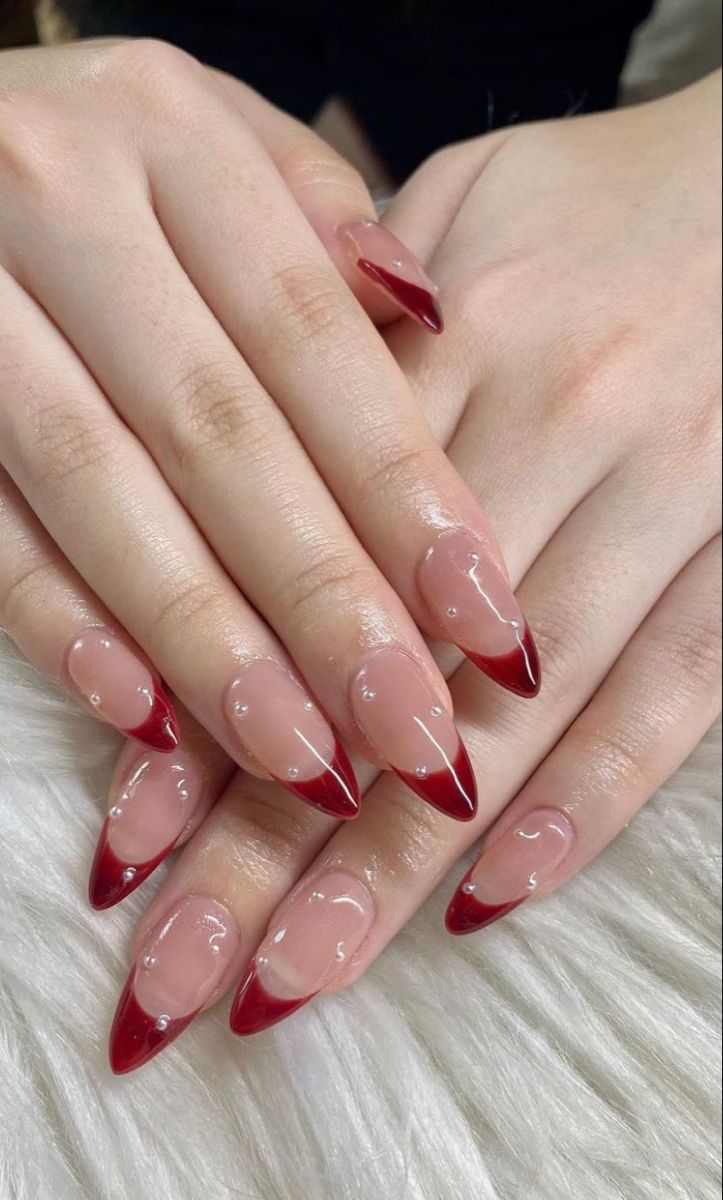 Elegant Almond-Shaped Nails: Translucent Nude Base with Bold Crimson Tips for a Chic Look.