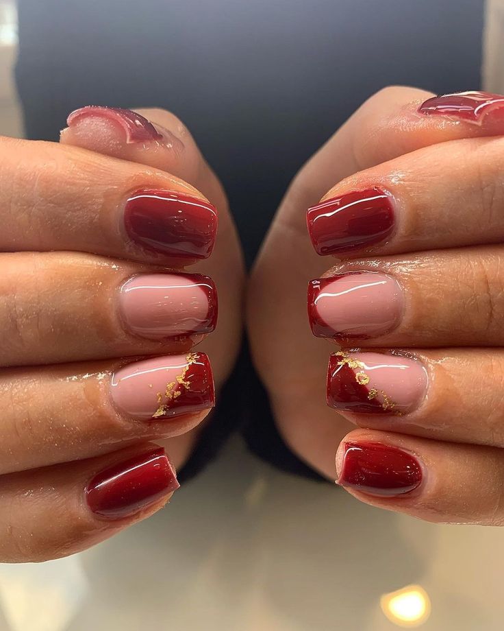 Elegant Nail Design: Luxurious Deep Reds and Soft Pinks with Gold Accents.