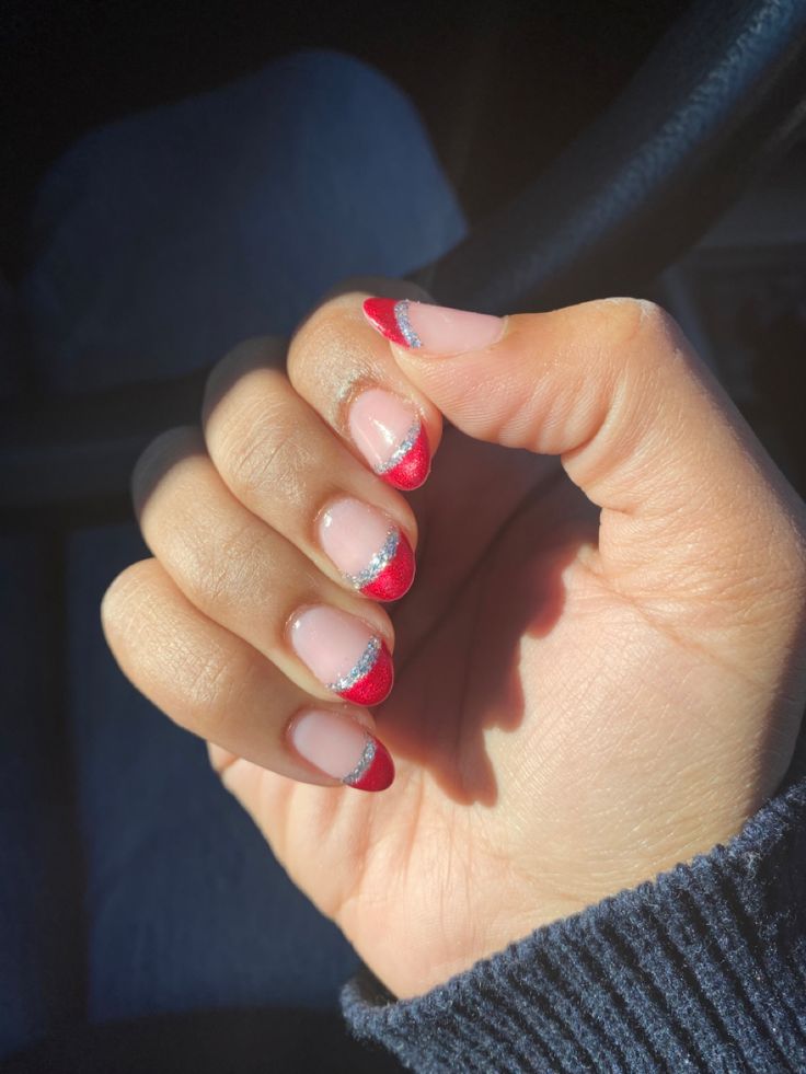 Chic Nude Base with Bold Red Tips and Glitter Accents for Elegant Nail Design.