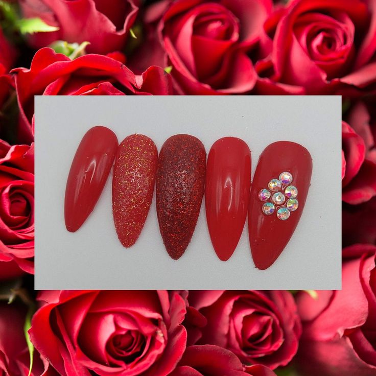 Elegant Red Nail Design with Gradient Shades, Textures, and Rhinestone Accents.