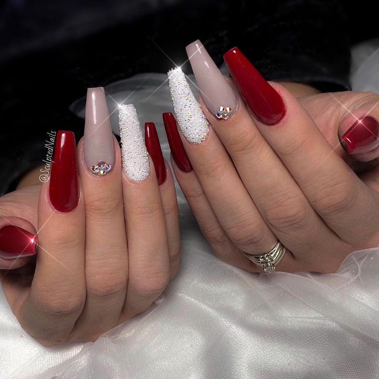 Elegant Long Ombre Nails with Glossy Red, Soft Nude Shades, Glitter Accents, and Gem Detail.