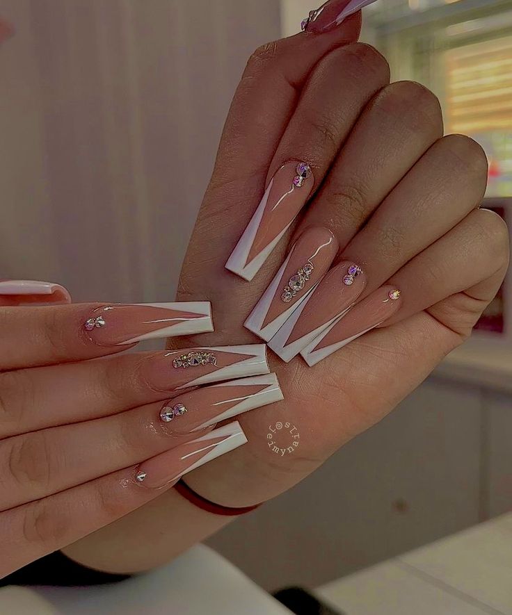 Sophisticated Chic Nail Design: Almond Shapes with French Tips and Sparkling Rhinestones.