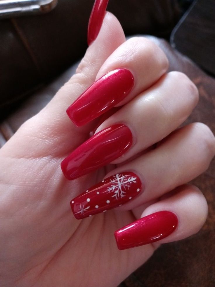 Festive Red Nails with Whimsical Snowflake Accent for a Cheerful Holiday Look.