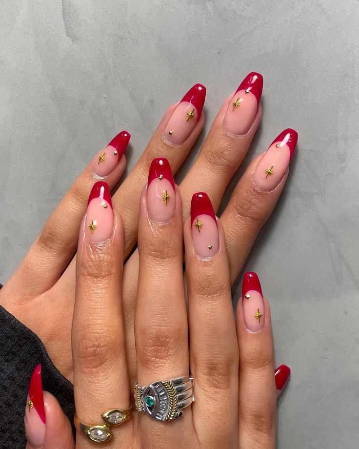 Chic Red French Tip Manicure with Soft Nude Base and Whimsical Gold Star Embellishments