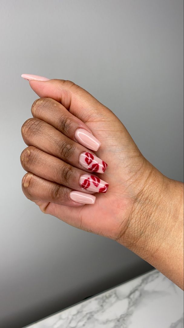 Elegant Almond-Shaped Nails with Nude Base and Bold Red Swirls