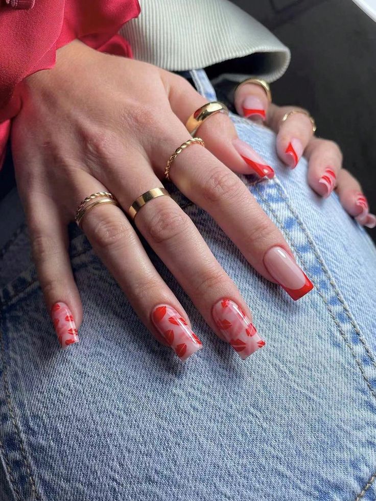 Chic Nail Art: Soft Pink and Vibrant Red with Geometric and Floral Patterns Accented by Delicate Gold Rings.